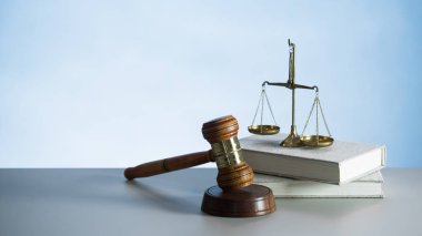 Ahşap masa arkasında hukuk ve adalet sembolleri..