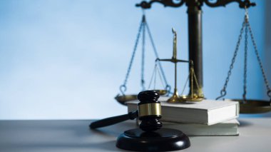 Ahşap masa arkasında hukuk ve adalet sembolleri..