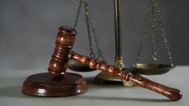 Hukuk ve Adaletin simgeleri hala duruyor. Ahşap masa arkasında tokmak ve pullar..