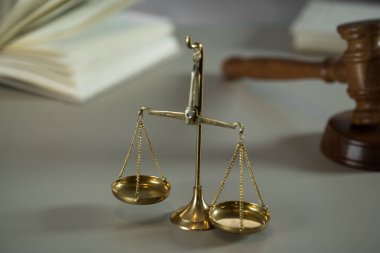Ahşap masa arkasında hukuk ve adalet sembolleri..