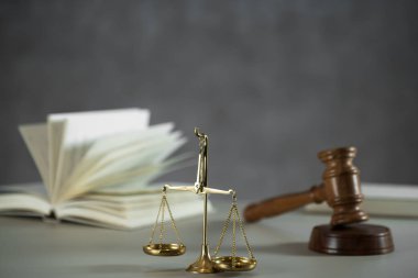 Ahşap masa arkasında hukuk ve adalet sembolleri..