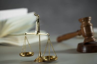 Ahşap masa arkasında hukuk ve adalet sembolleri..