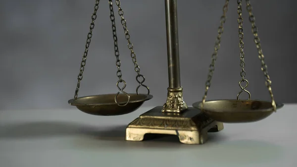 Still life of Law and Justice symbol - scales on wooden table background.