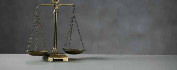 Still life of Law and Justice symbol - scales on wooden table background.