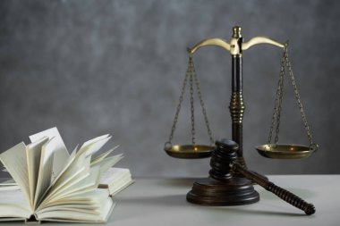 Ahşap masa arkasında hukuk ve adalet sembolleri..