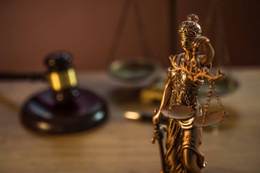 Ahşap masa arkasında hukuk ve adalet sembolleri..