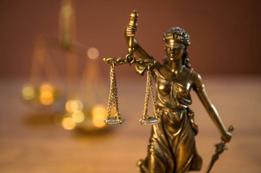 Ahşap masa arkasında hukuk ve adalet sembolleri..