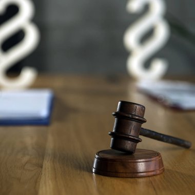 Gavel ahşap masa arkasında bulanık kitaplarla