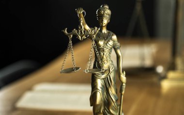 Kör Goddes Themis ahşap masa arkaplanında bulanık belgelerle terazi tutuyor.