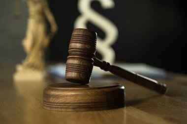 Gavel ahşap masa arkasında bulanık kitaplarla
