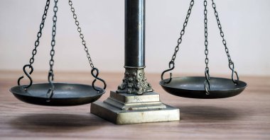 Ahşap masa arkasında adalet terazileri