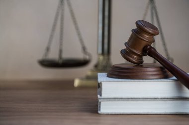 Ahşap masa arkasında hukukun ve adaletin sembolleri