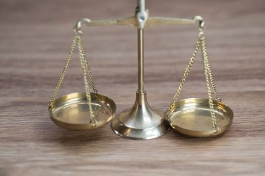 Ahşap masa arkasında adalet terazileri
