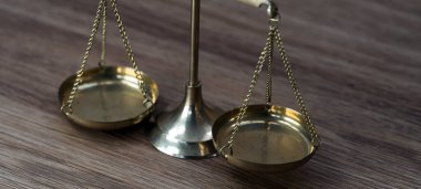 Ahşap masa arkasında adalet terazileri