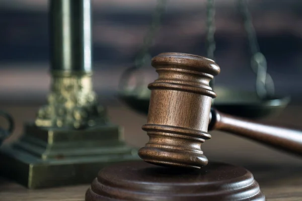 木制桌子背景上的法律和司法象征 — 图库照片