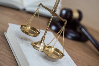 Ahşap masa arkasında hukukun ve adaletin sembolleri