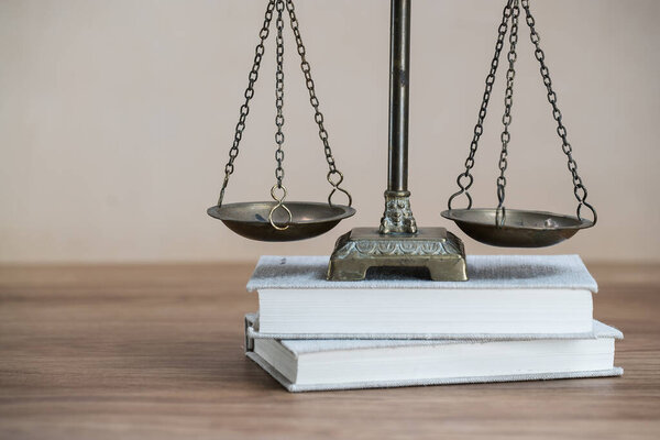 Scales of justice on wooden table background