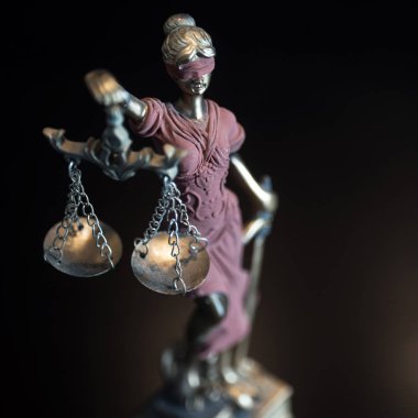 Kör Goddes Themis arka planda bulanık pullar tutuyor.