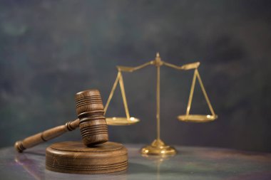 Ahşap masa arkasında hukukun ve adaletin sembolleri