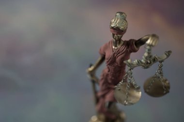Kör Goddes Themis arka planda bulanık pullar tutuyor.