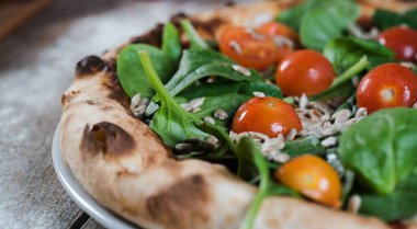 Kiraz domatesli pizza, ıspanak ve ay çekirdeği.