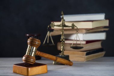 Ahşap masa arkasında hukukun ve adaletin sembolleri. Yargıç ofisi.