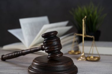 Ahşap masa arkasında hukukun ve adaletin sembolleri. Yargıç ofisi.