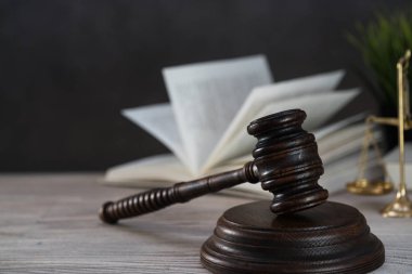 Ahşap masa arkasında hukukun ve adaletin sembolleri. Yargıç ofisi.