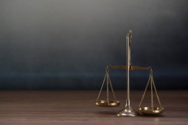 Ahşap masa arkasında adalet terazileri