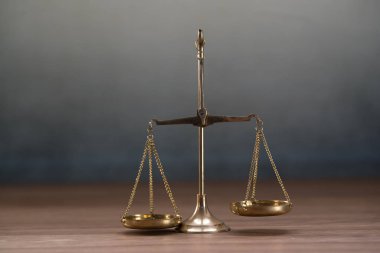 Ahşap masa arkasında adalet terazileri