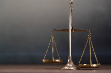 Ahşap masa arkasında adalet terazileri
