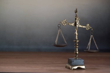 Ahşap masa arkasında adalet terazileri