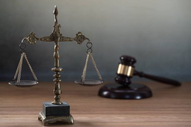 Ahşap masa arkasında hukukun ve adaletin sembolleri. Yargıç ofisi.