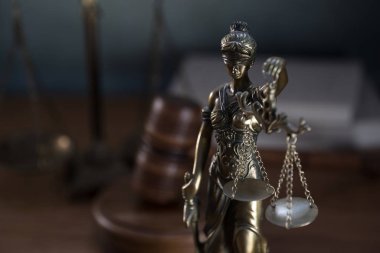 Ahşap masa arkasında hukukun ve adaletin sembolleri. Yargıç ofisi.