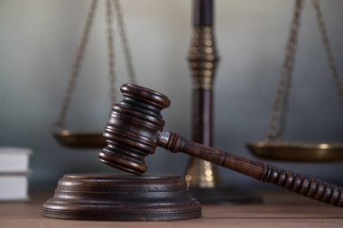 Ahşap masa arkasında hukukun ve adaletin sembolleri. Yargıç ofisi.