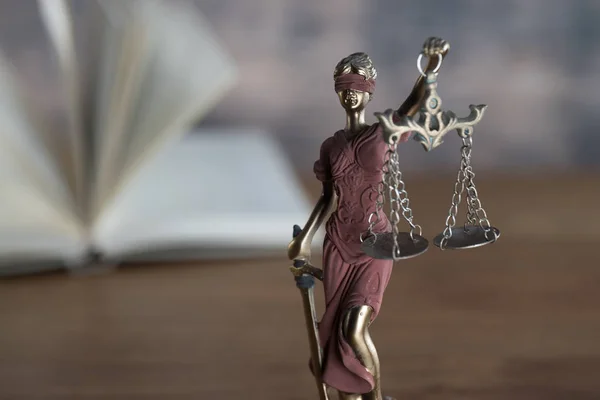 closeup view of Themis sculpture with scale on table, jurisprudence concept