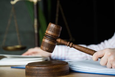 El ele tutuşmak ve kitap okumak, arka planda adalet terazisi. Hukuk hukuku ve adalet kavramı.