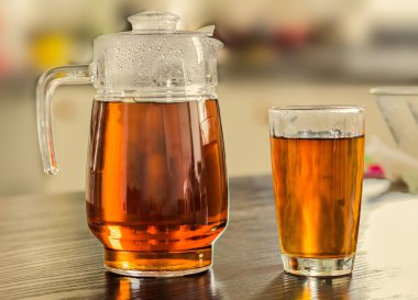 Sürahi ve bardak sıcak siyah çay mutfak üzerinde 