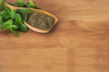 Bir kesme tahtası üzerinde zemin fesleğen tam kaşıkla fesleğen yaprakları.