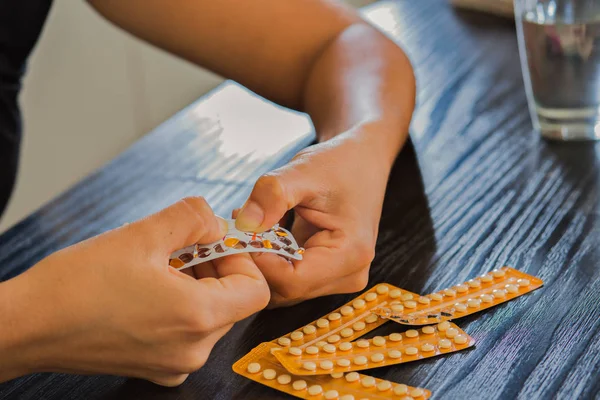 Vrouw handen openen geboortebeperking pillen. — Stockfoto