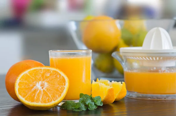 Glas und Saftpresse mit frisch gepresstem Orangensaft. — Stockfoto