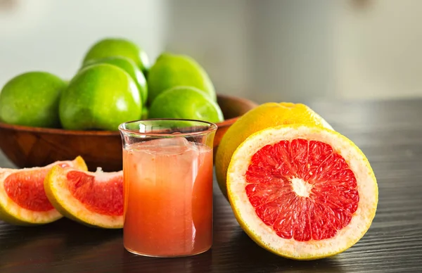 Склянка свіжовичавленого грейпфрутового соку з шматочками грейпфрута . — стокове фото