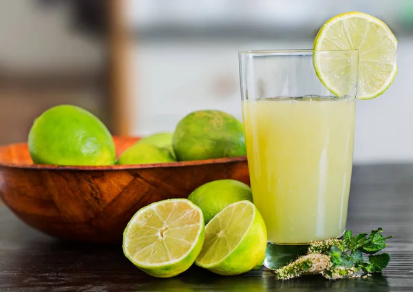 Glas frisch gepresster Zitronensaft mit geschnittener und ganzer Zitrone — Stockfoto