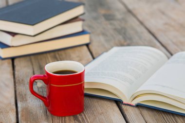 Yığın kapalı kitap ve kahve ile açık kitap 