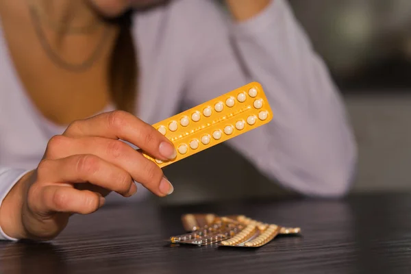 Donna in possesso di confezione di pillole contraccettive e bicchiere d'acqua . — Foto Stock