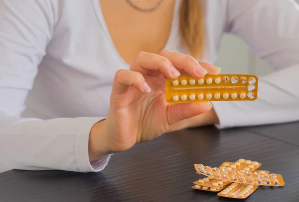 Paket doğum kontrol hapları ve su tutan kadın.