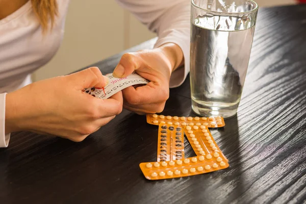 Paket doğum kontrol hapları ve su tutan kadın.