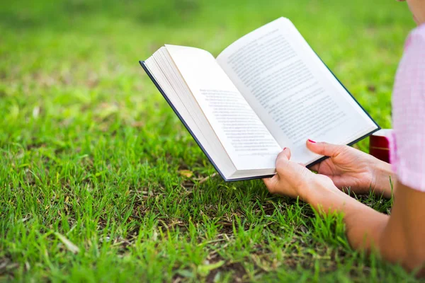 Kobieta czytająca otwartej książki na trawie — Zdjęcie stockowe