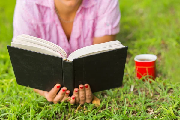 Kobieta czytająca książkę na trawie — Zdjęcie stockowe