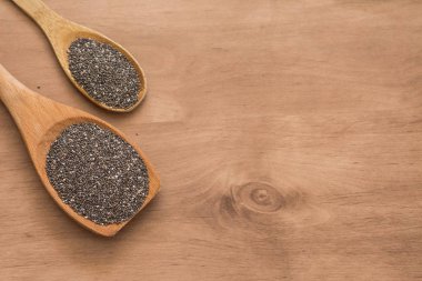 Tahta kaşıkla chia tohum ahşap arka plan üzerinde.
